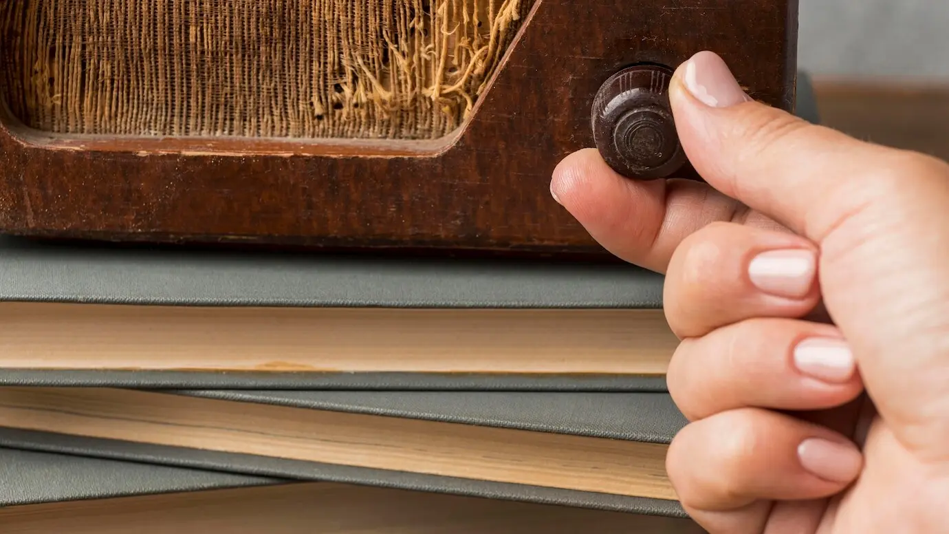 Крупный план человека, использующего кнопку винтажного радио.